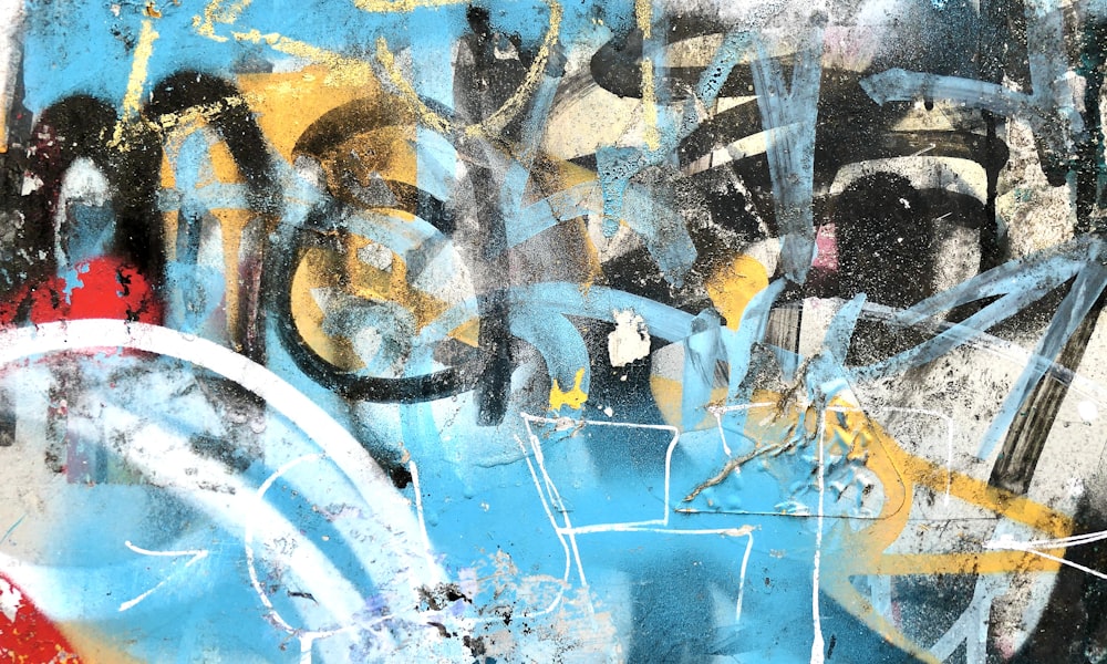 a blue and yellow wall with graffiti on it