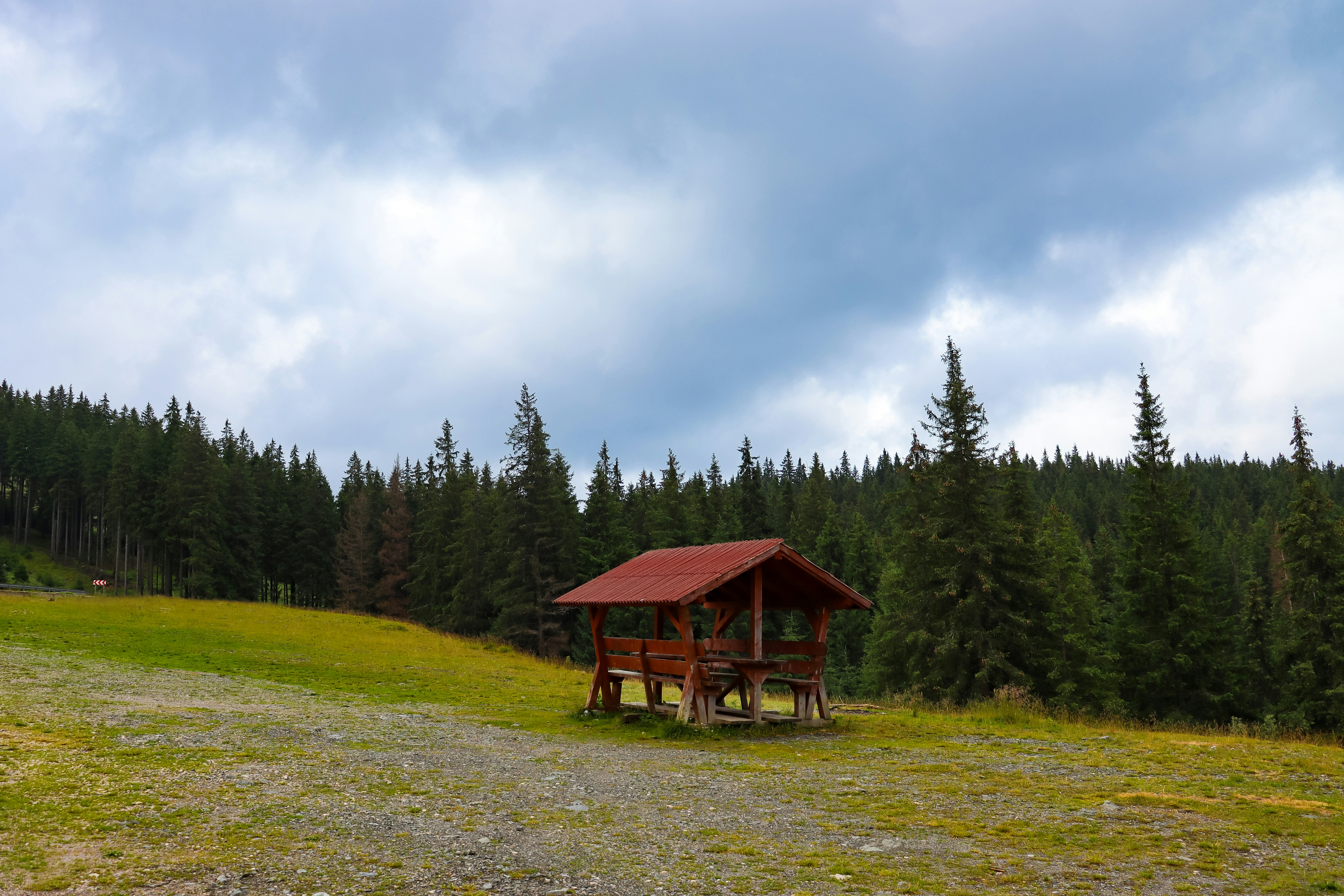 a cabin in the middle of a field with trees in the background
