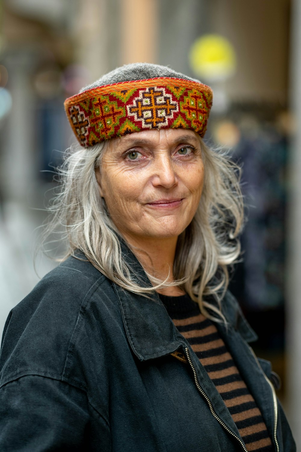 a woman with grey hair wearing a hat