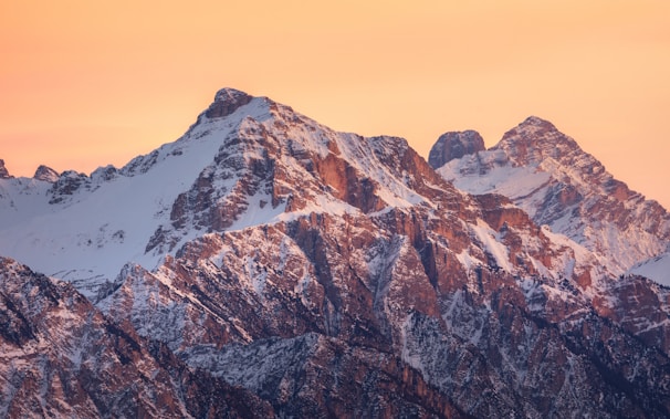 A panoramic view of rugged mountain peaks glowing in the golden hour light