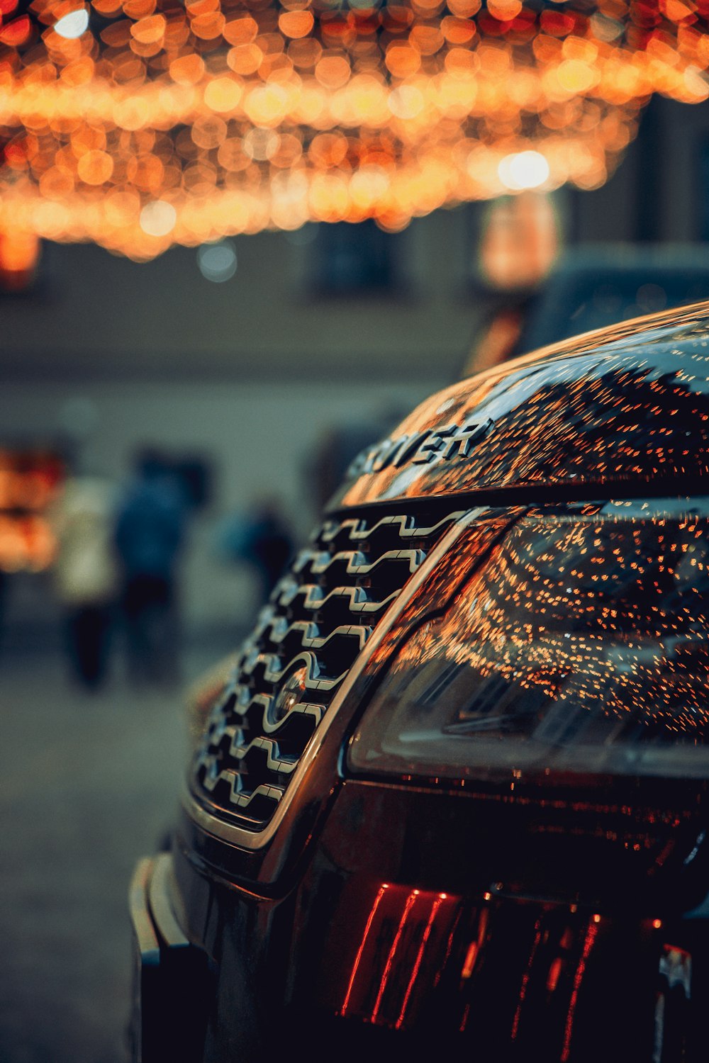 a close up of a car with lights in the background