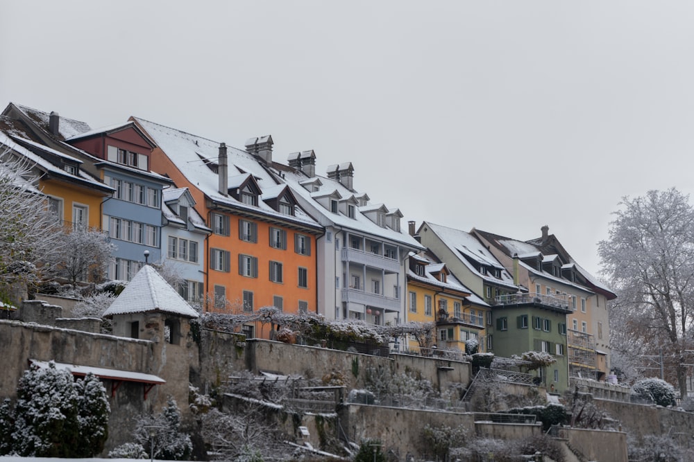 a row of houses on a hill covered in snow