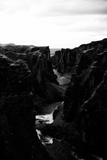 Artistic black and white shot of a winding river cutting through a vast valley at dawn.