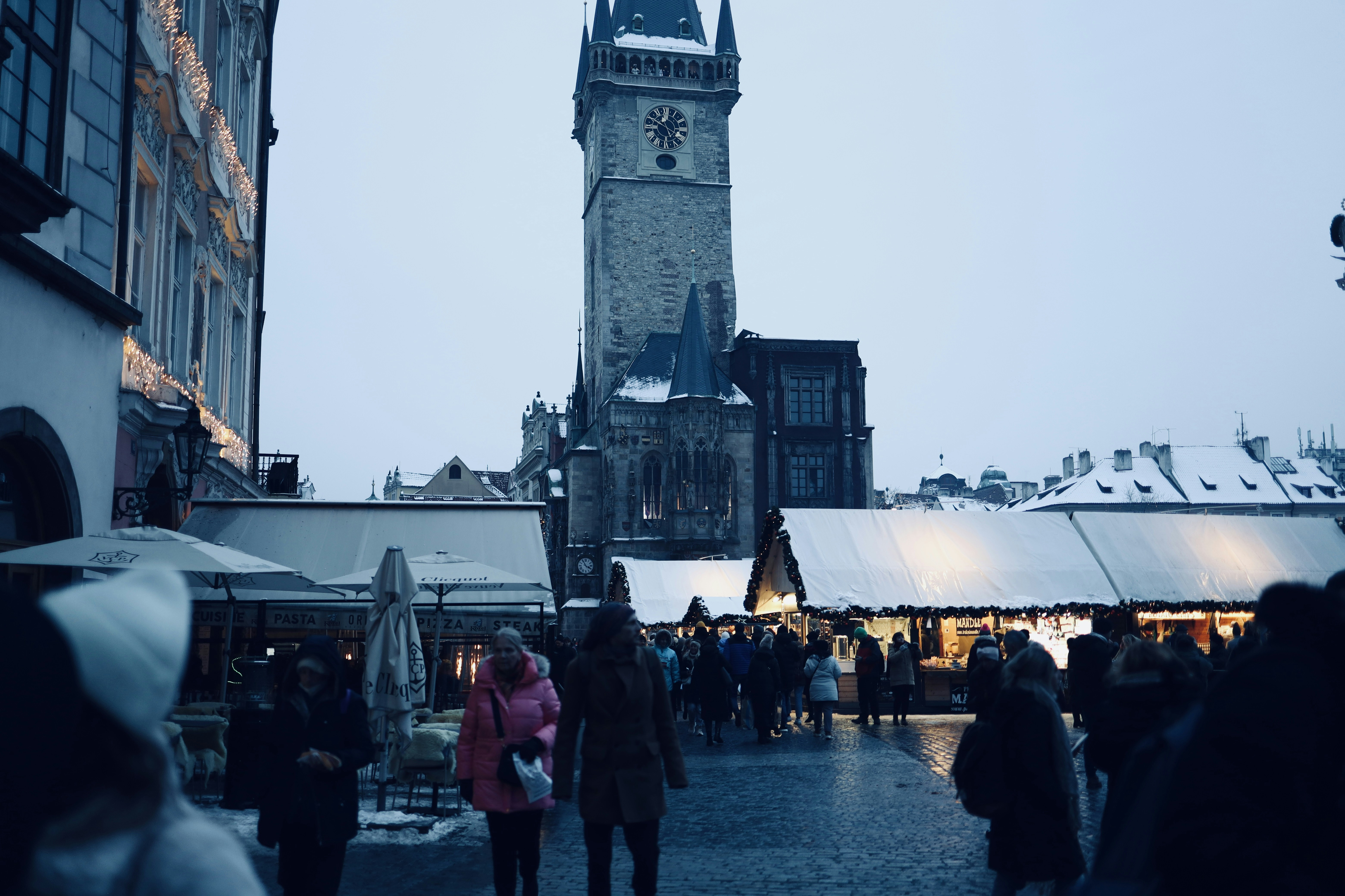 a large clock tower towering over a city filled with people
