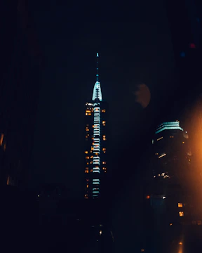 Night view of a commercial building illuminated with blue and white lights.