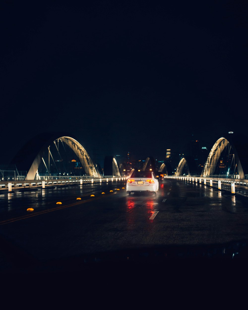 a car driving across a bridge at night