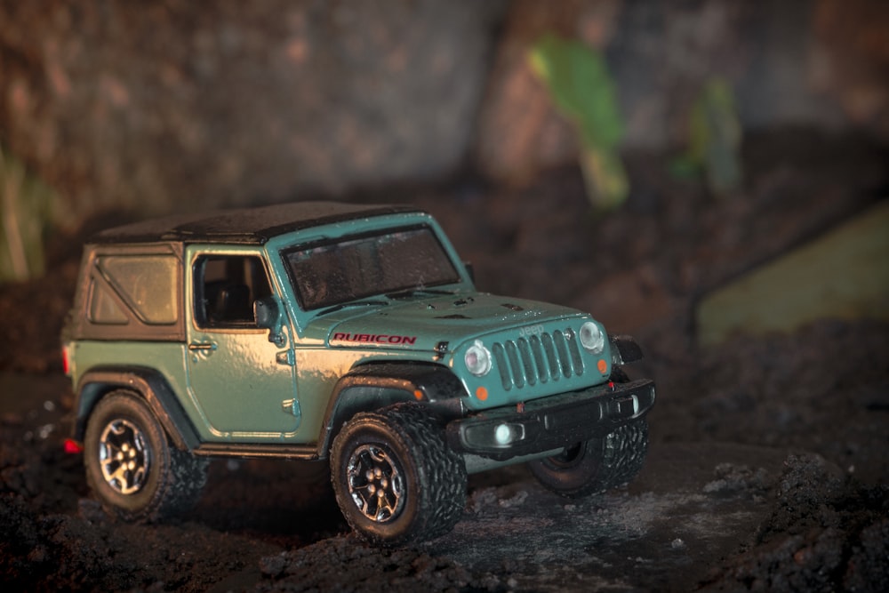a toy jeep is parked in the mud