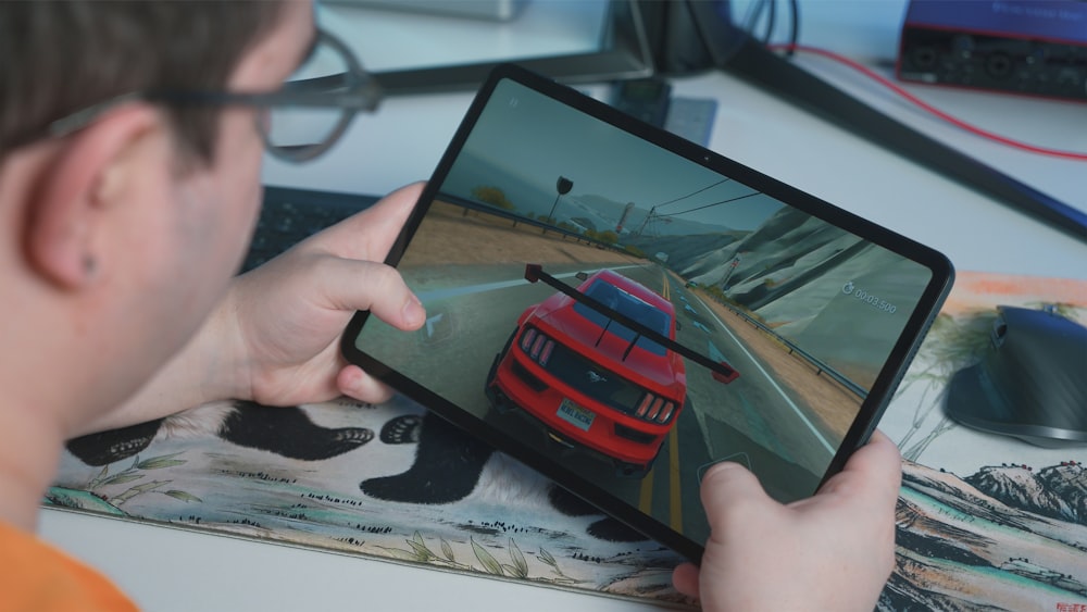 a man is playing a video game on his tablet