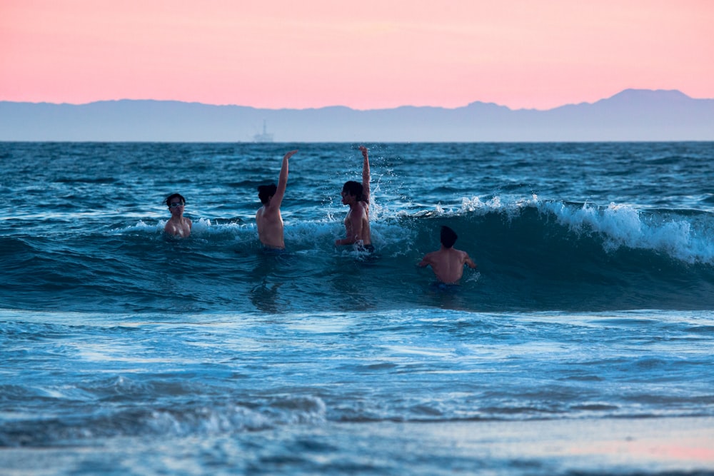 a group of people riding waves on top of surfboards