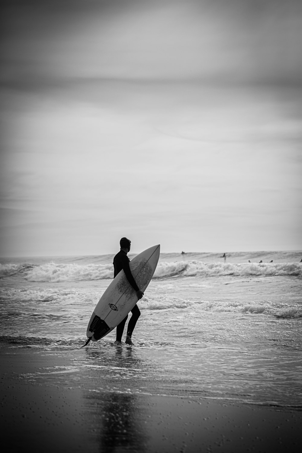 a man holding a surfboard on top of a beach