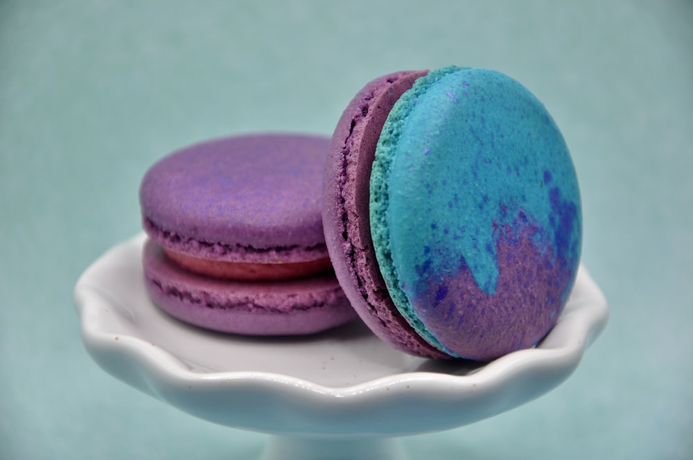 two colorful macaroons sitting on a white plate