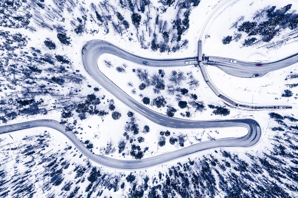 an aerial view of a winding road in the snow