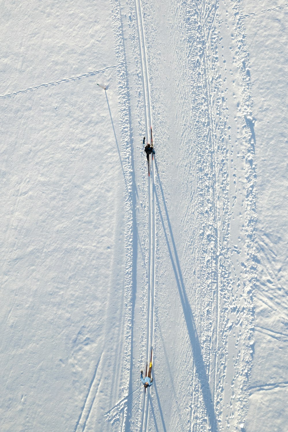 Un par de personas montando esquís por una pendiente cubierta de nieve