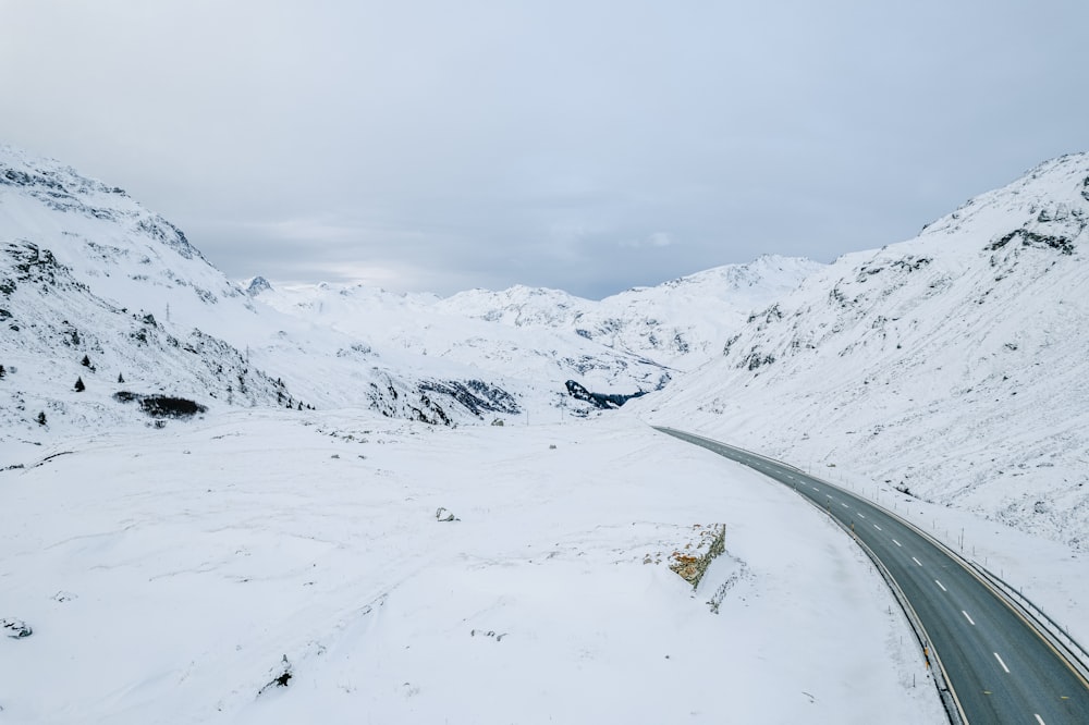 a long road in the middle of a snowy mountain