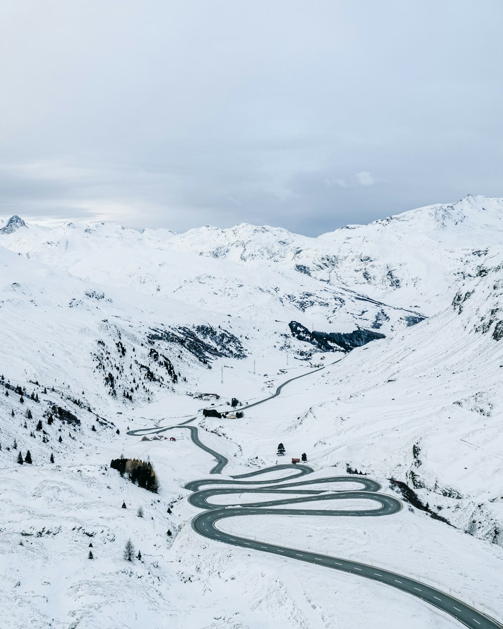 a winding road in the middle of a snowy mountain