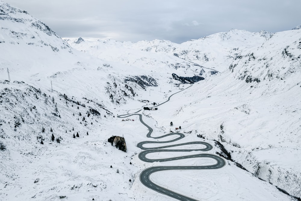 uma estrada sinuosa no meio de uma montanha nevada
