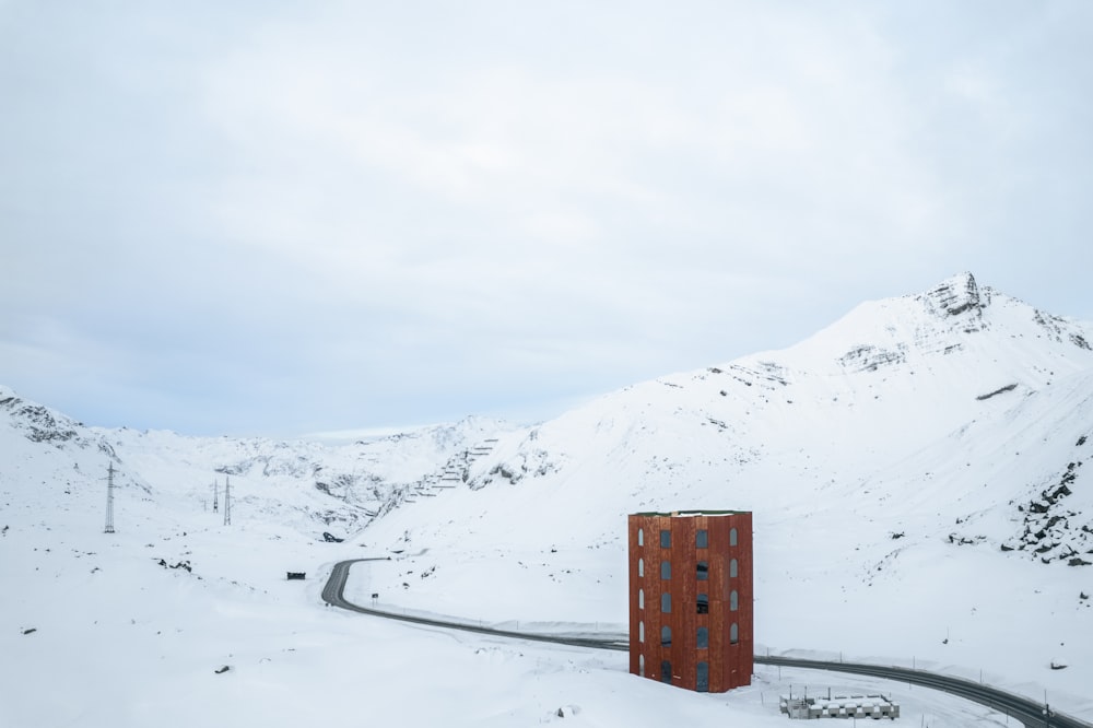 a red building sitting on the side of a snow covered road