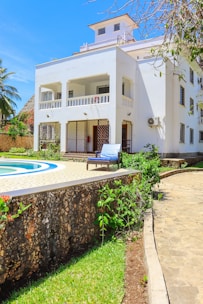 a large white house with a pool in front of it
