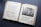 An open antique book featuring pages with text in an old font style on the left and an illustration on the right. The illustration depicts a biblical scene with several figures in a historical setting. The paper appears aged, with yellowed edges and some wear.