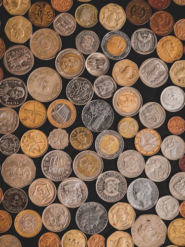 A pile of different historical coins representing the evolution of gold coinage