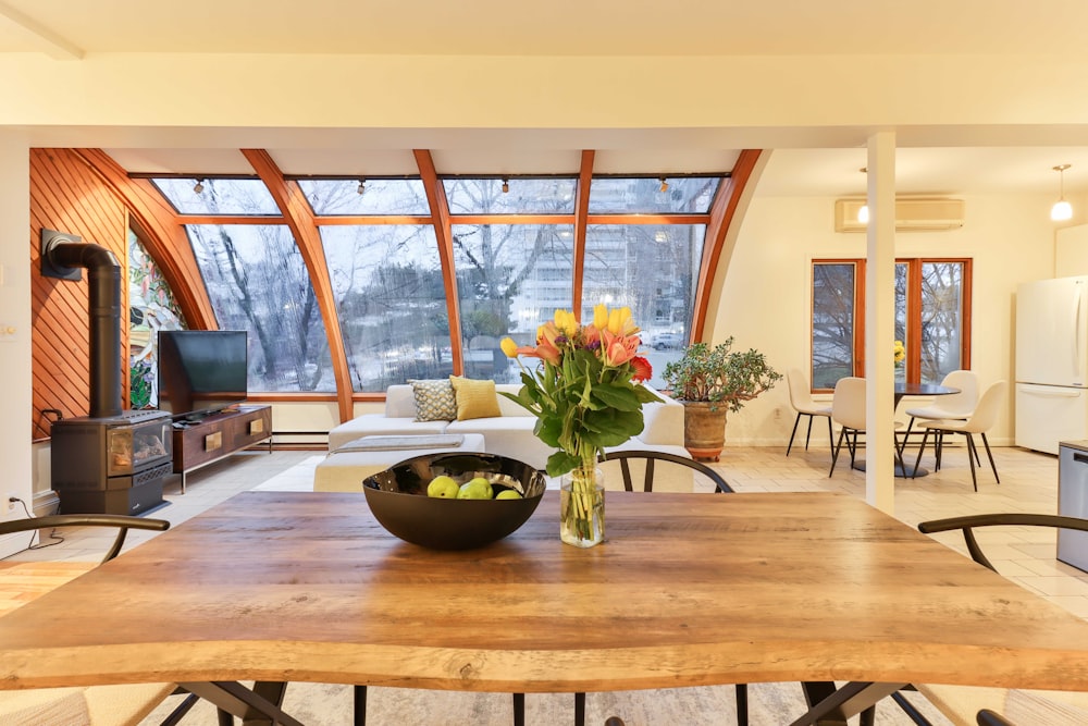 a dining room table with a bowl of fruit on it