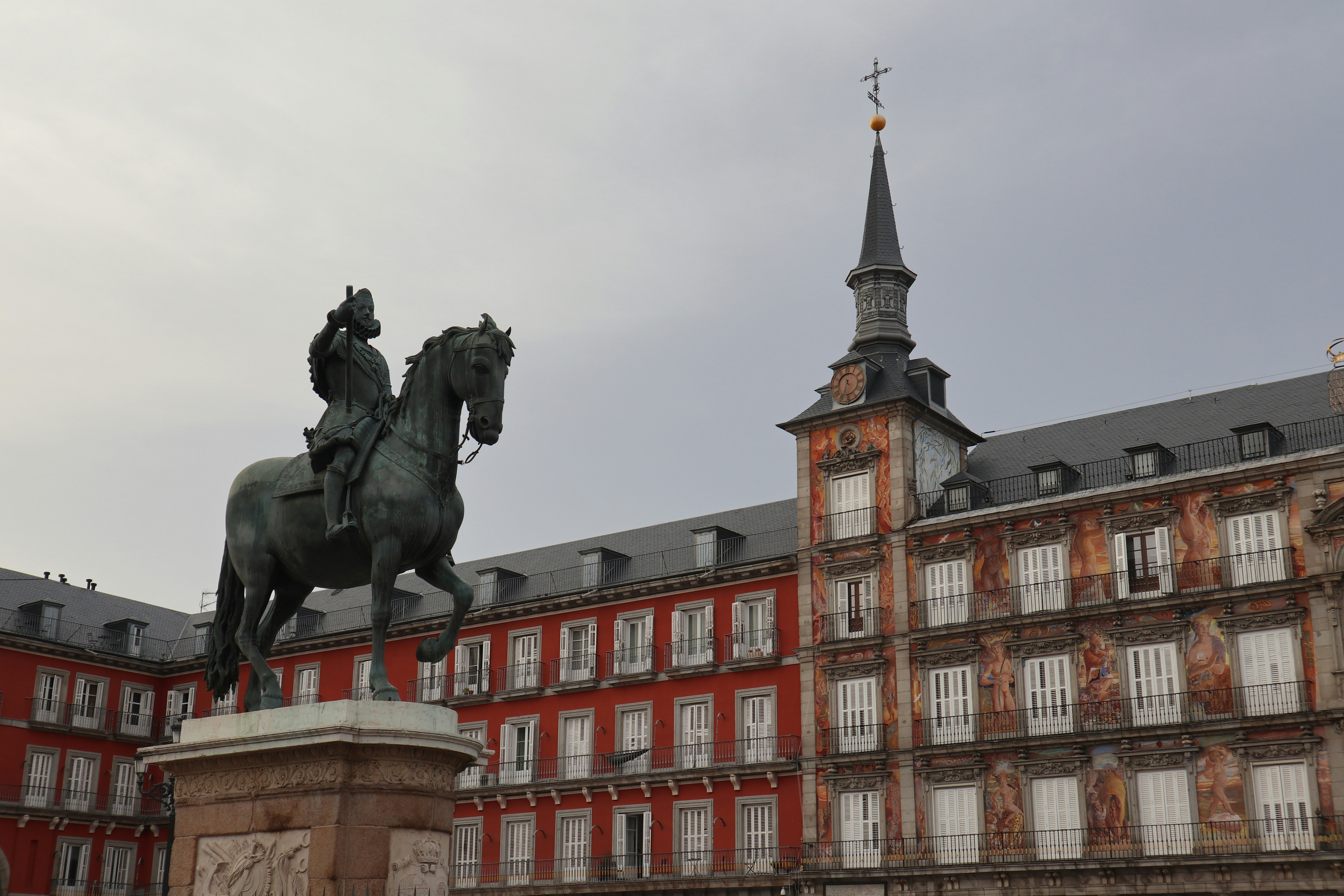 a statue of a man on a horse in front of a building