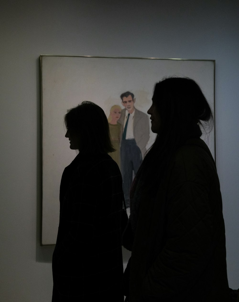 a couple of people standing in front of a painting