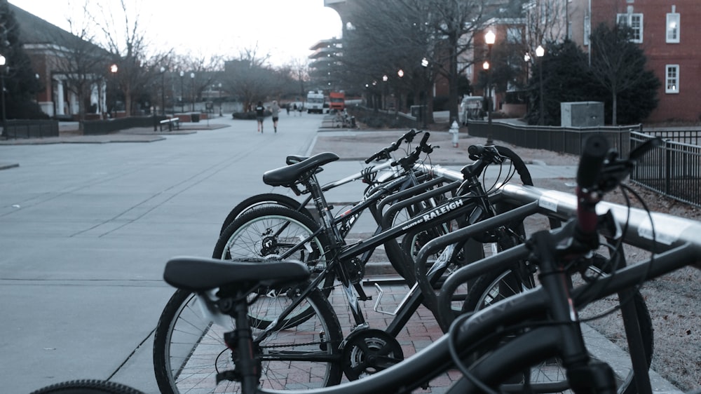 a row of bikes parked next to each other on a sidewalk