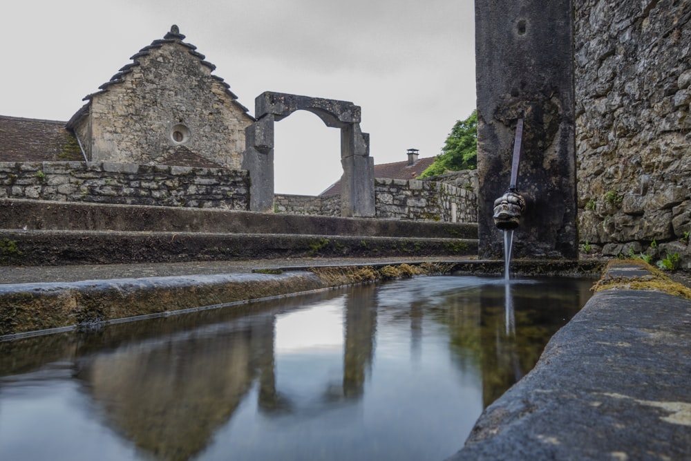 a small stream of water running through a stone wall