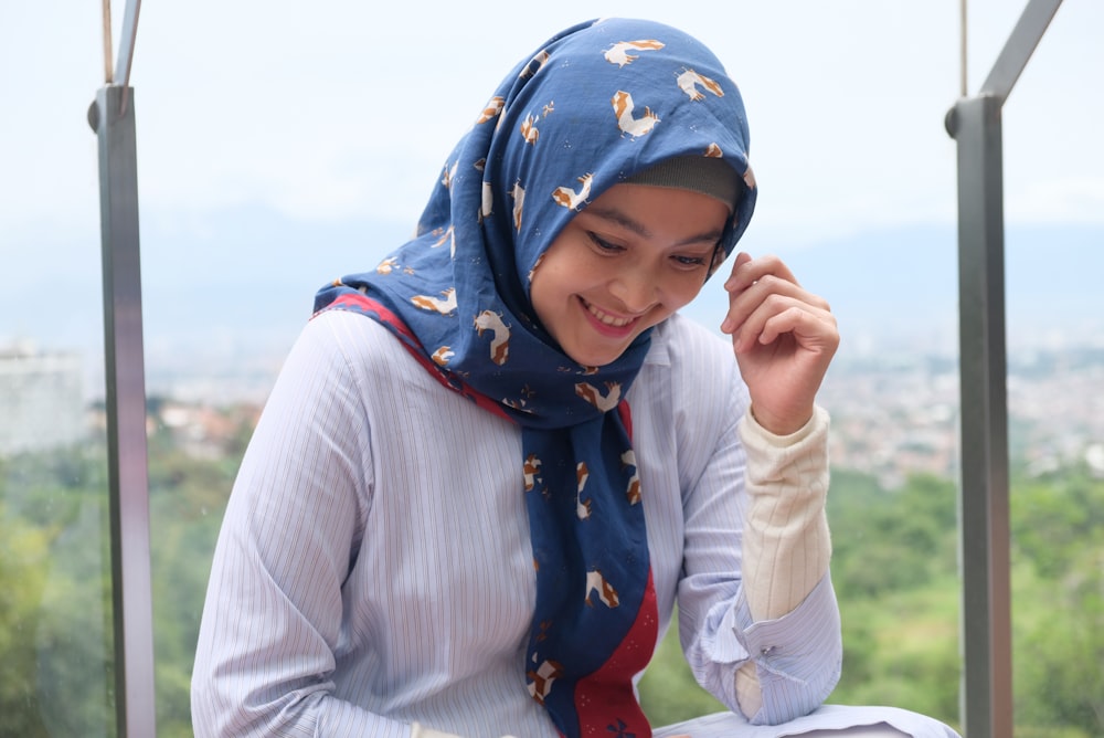 a woman wearing a blue scarf and a white shirt