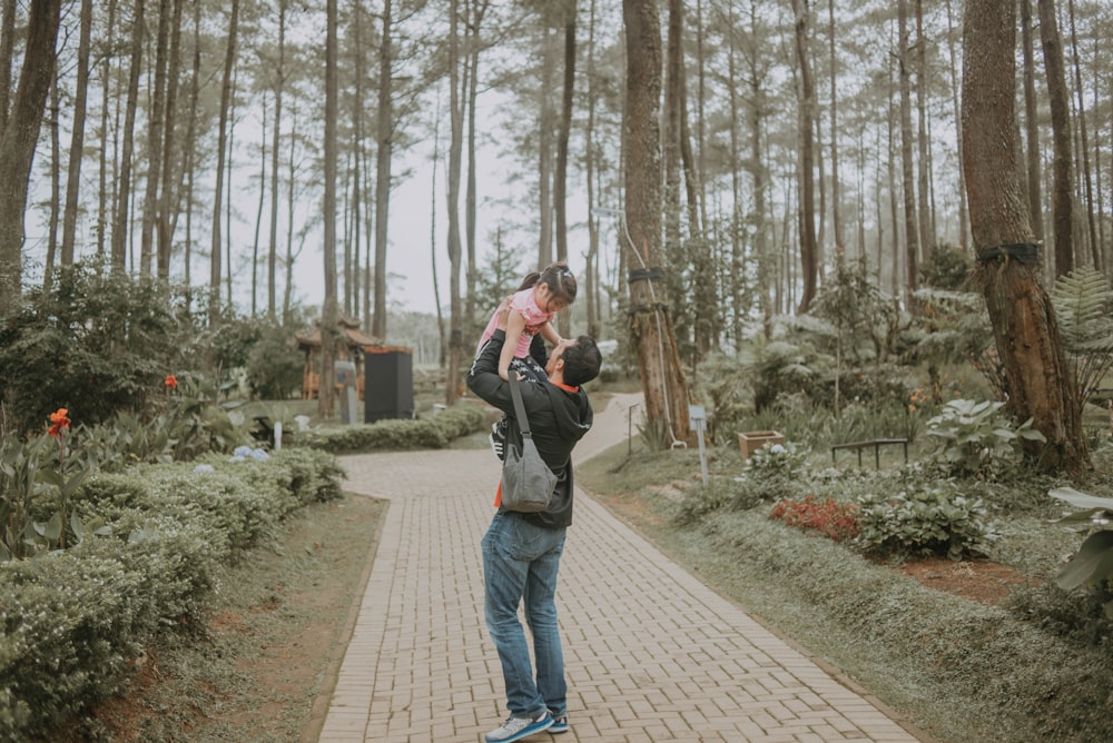 a man holding a baby up in the air