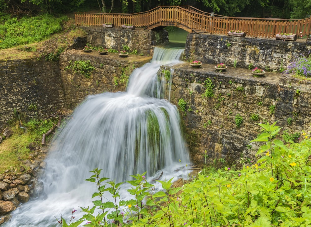a waterfall with a wooden bridge over it