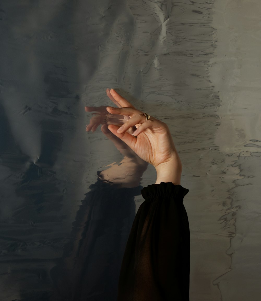 a woman holding her hand up to the ceiling