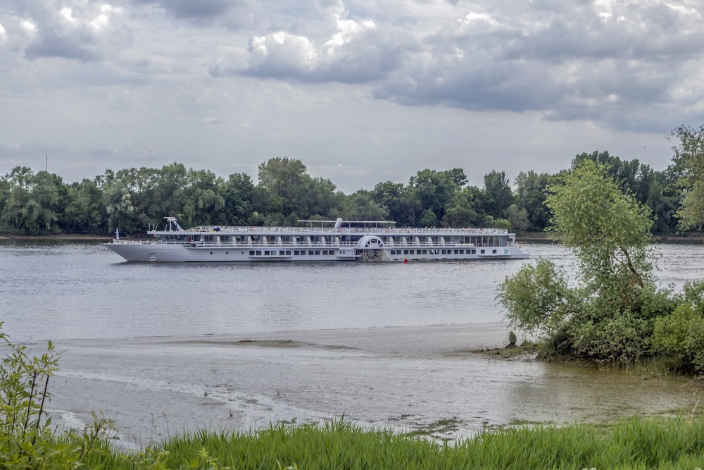 a large boat on a river with trees in the background