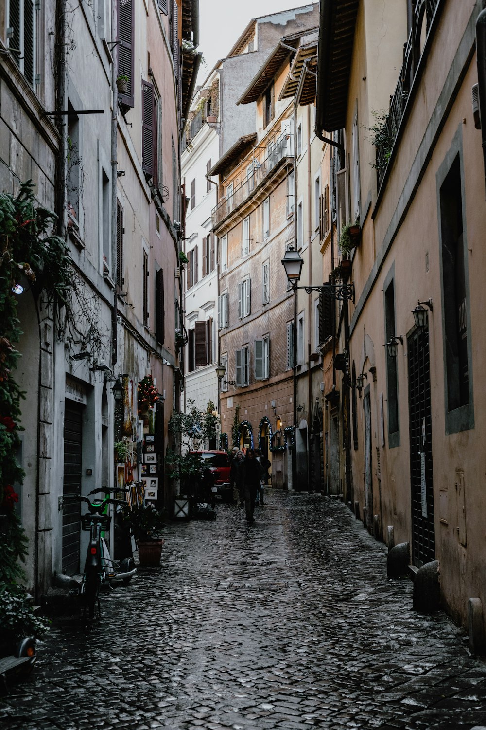 a cobblestone street with people walking down it