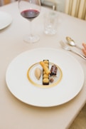 a plate of food on a table with a glass of wine