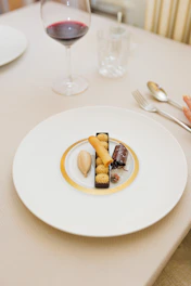 a plate of food on a table with a glass of wine