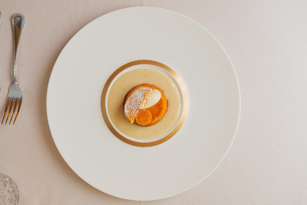 un piatto bianco sormontato da una fetta d'arancia