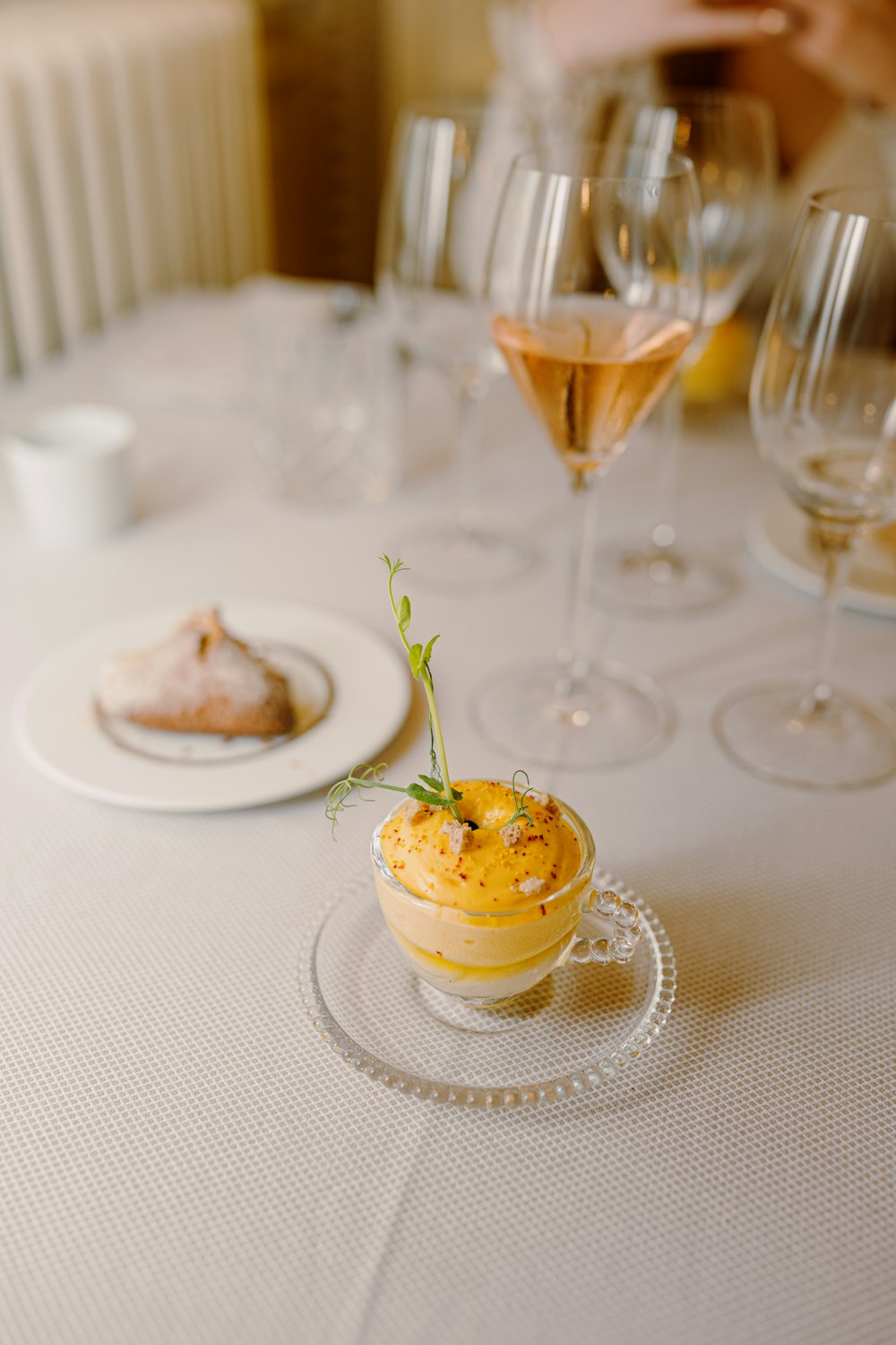 a table topped with glasses of wine and a plate of food