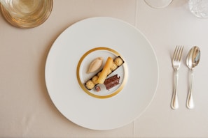Artfully arranged dessert with delicate details and a touch of gold accent on a cream plate