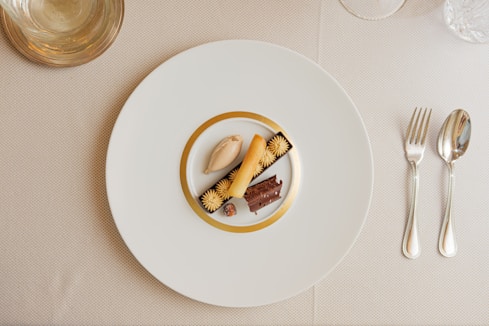 a white plate topped with a piece of cake next to a fork