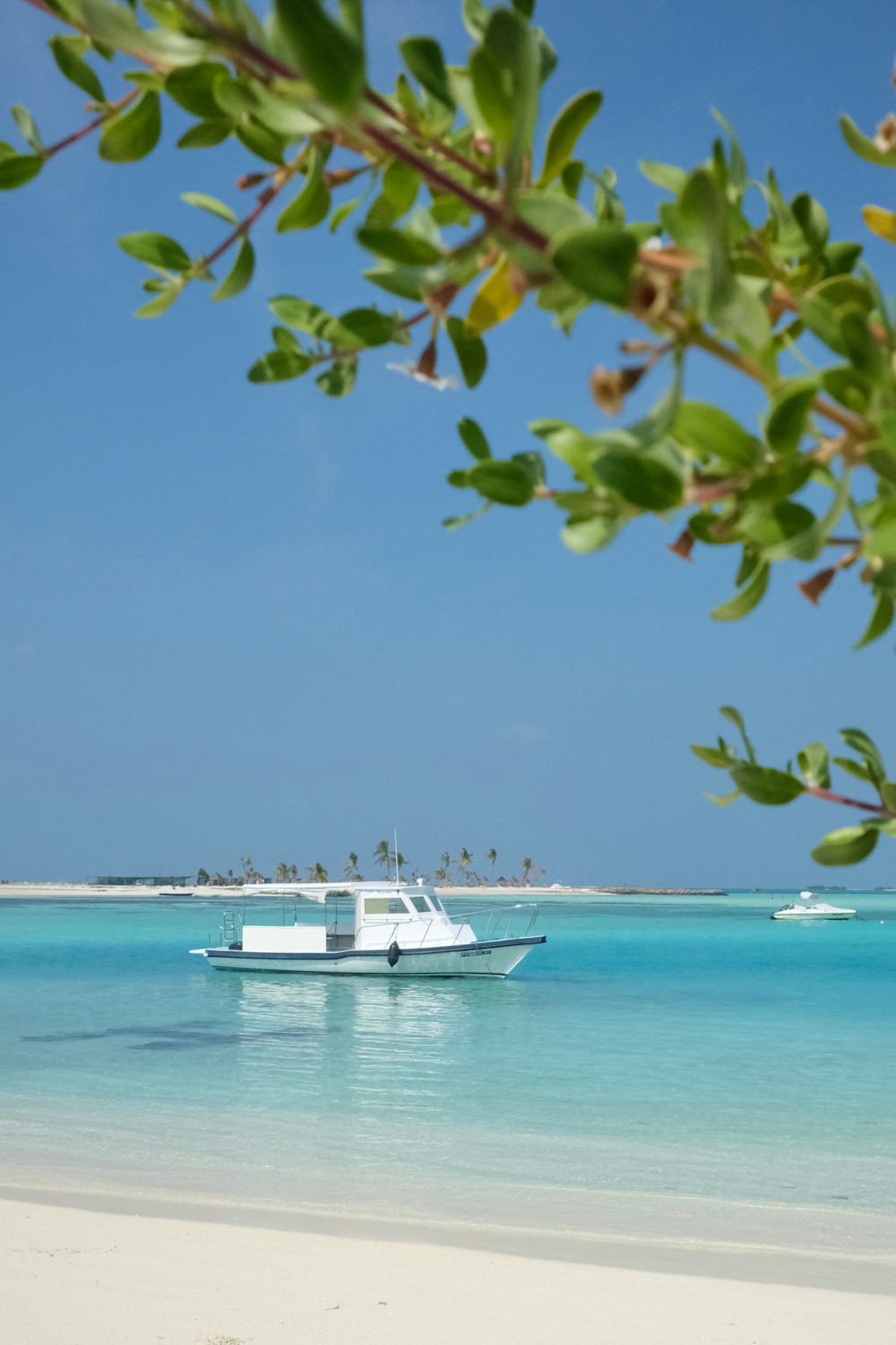 a white boat floating on top of a blue ocean