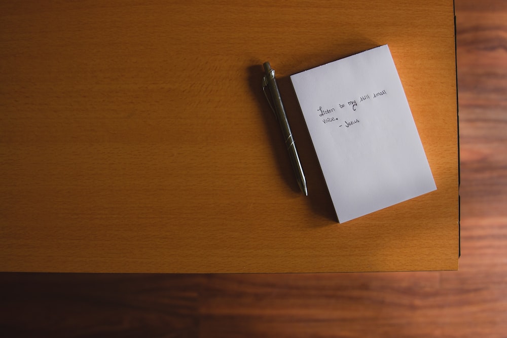 a note pad with a pen on a wooden table