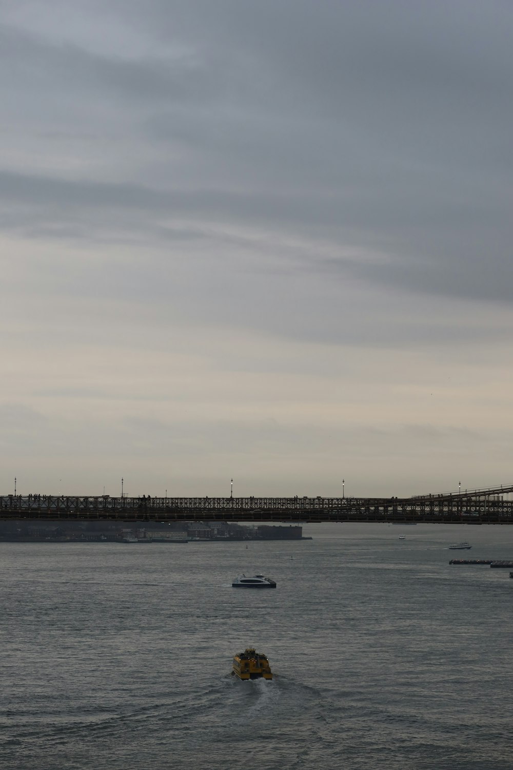 a body of water with a bridge in the background