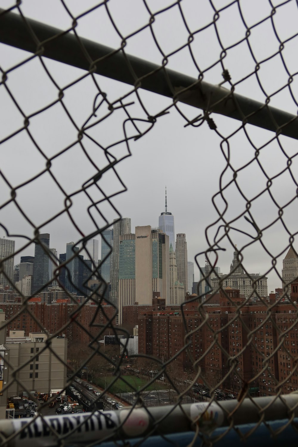 a view of a city from behind a fence