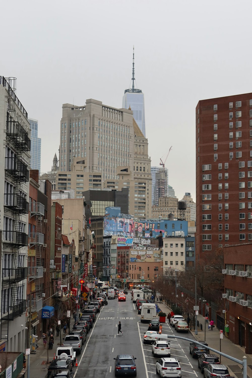 a city street filled with lots of traffic next to tall buildings