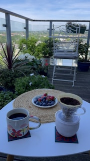 A compact balcony table made of smooth stone, perfect for morning coffee with a city view.