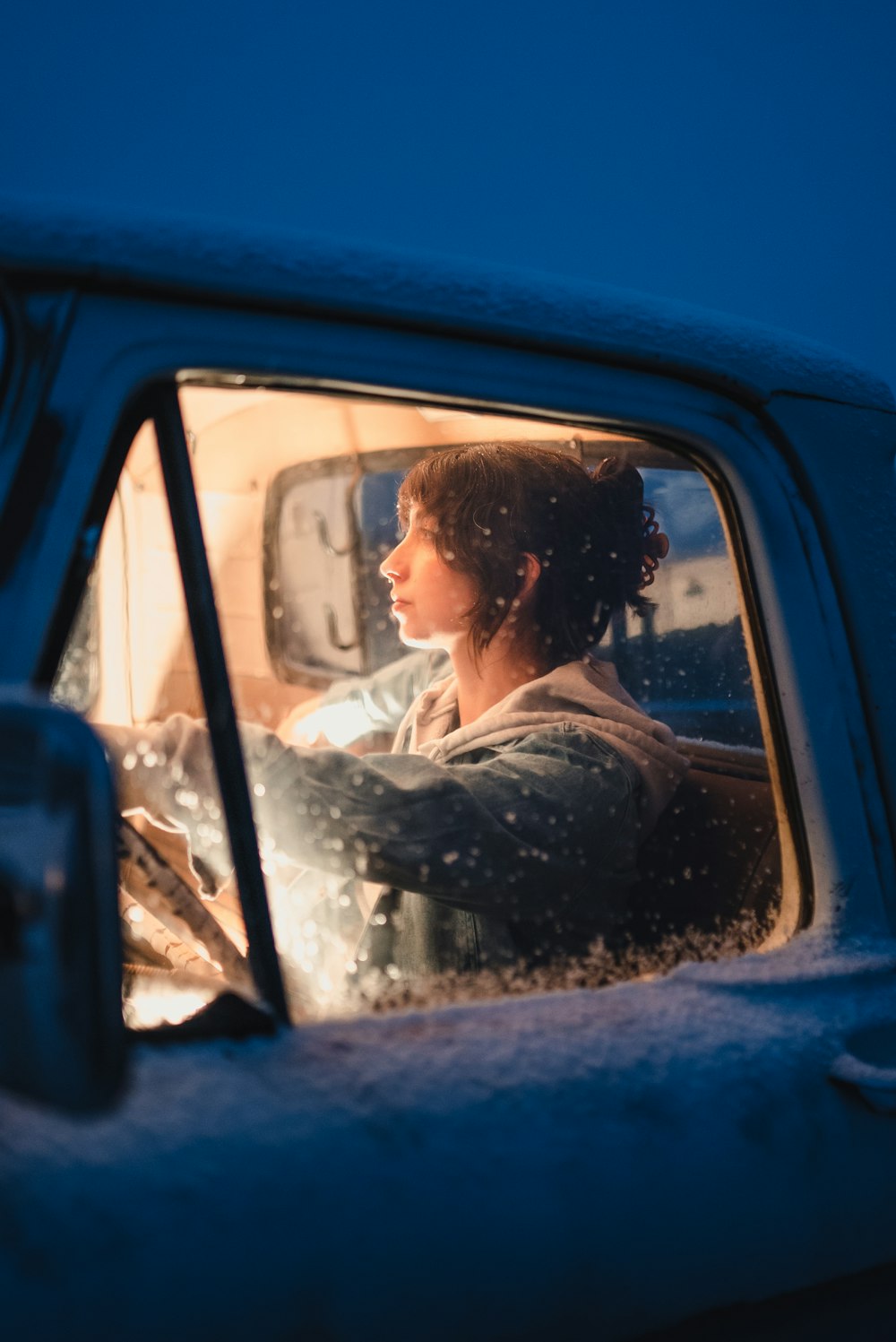 a woman driving a truck in the snow