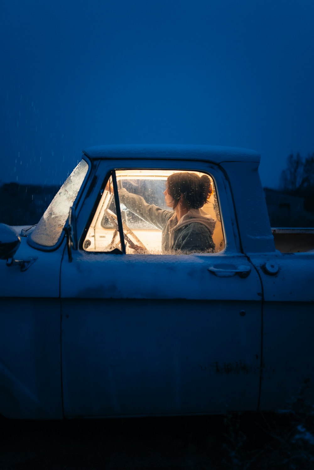 a woman driving a truck in the snow