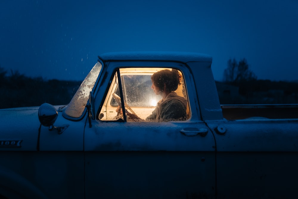 a woman sitting in the passenger seat of a truck